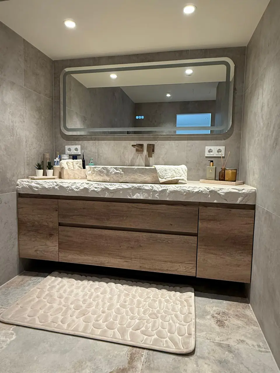 Detalle del baño de la casa de Eliseo y Sophie con piedra, madera y acabados en bronce 8