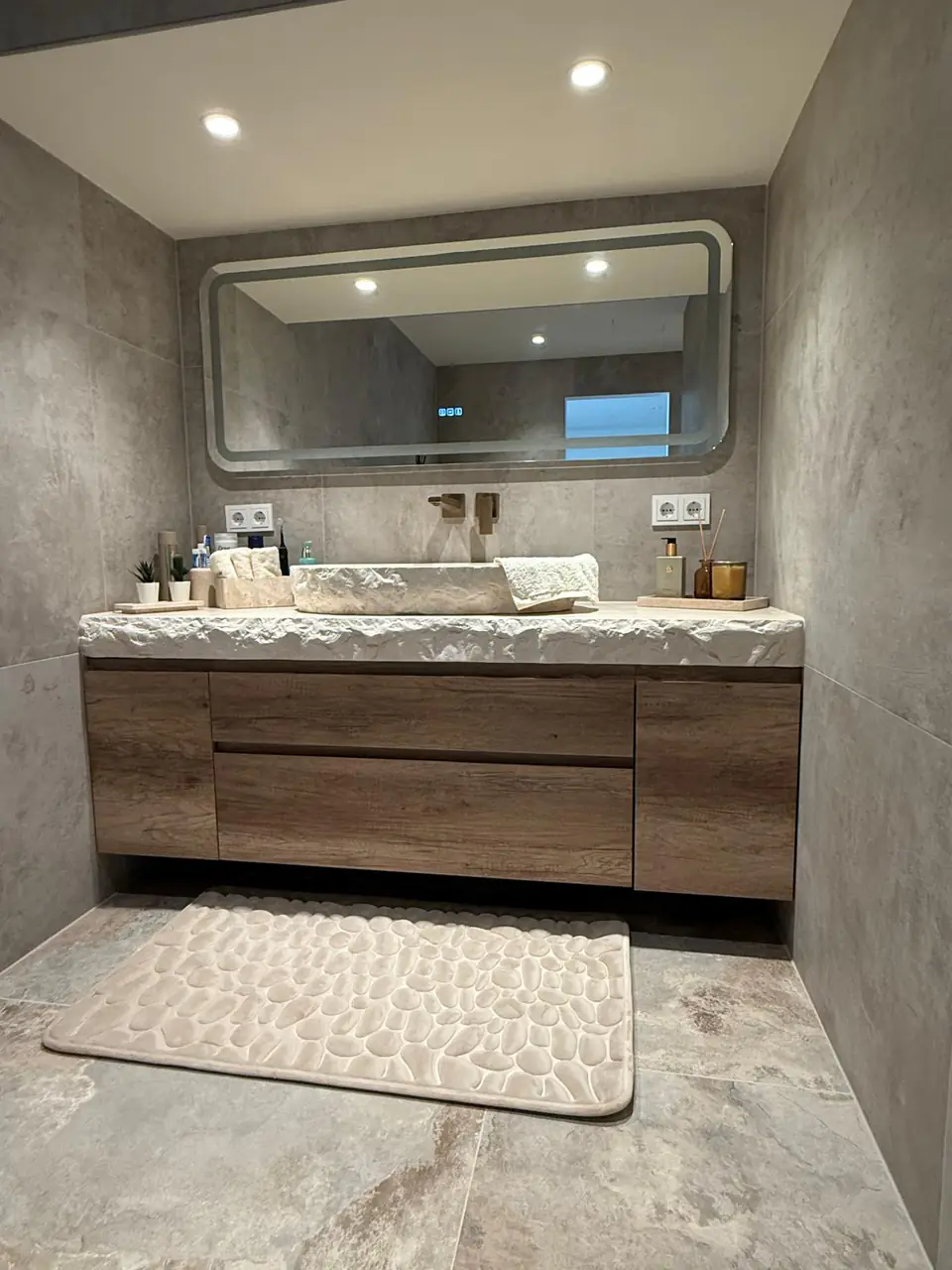 Detalle del baño de la casa de Eliseo y Sophie con piedra, madera y acabados en bronce 9