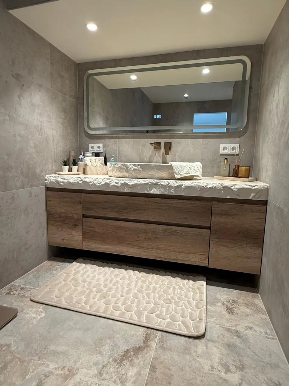 Detalle del baño de la casa de Eliseo y Sophie con piedra, madera y acabados en bronce 10