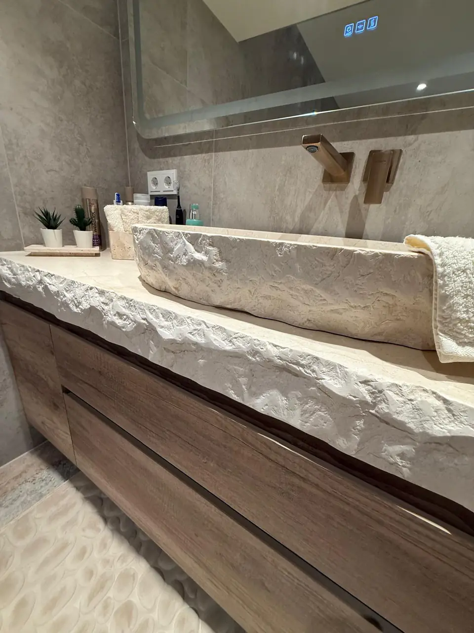 Detalle del baño de la casa de Eliseo y Sophie con piedra, madera y acabados en bronce 13