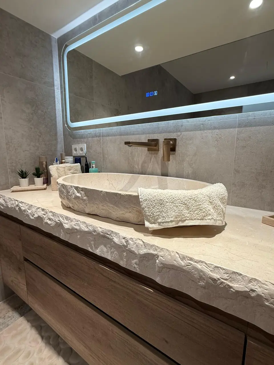 Detalle del baño de la casa de Eliseo y Sophie con piedra, madera y acabados en bronce 19