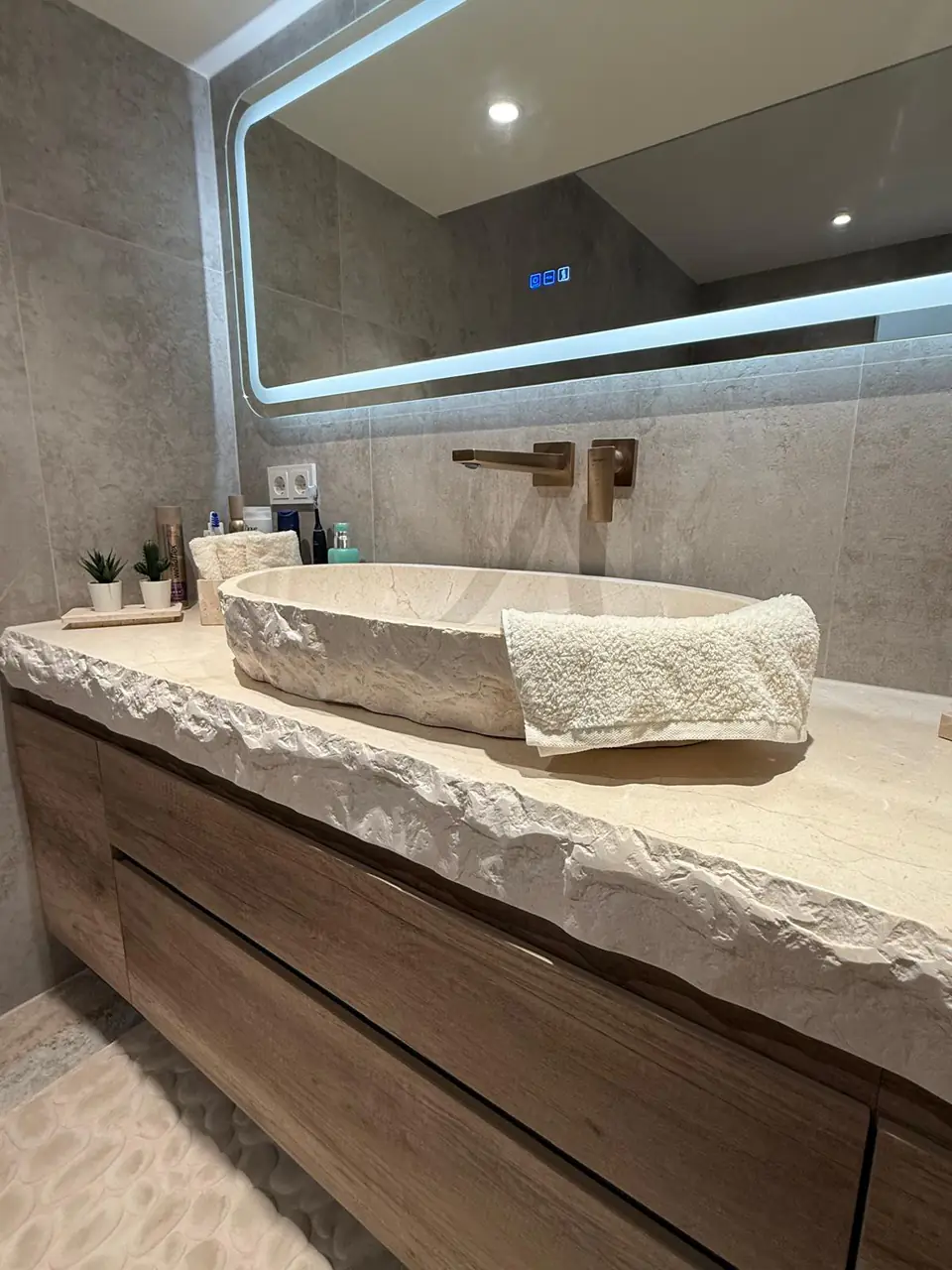 Detalle del baño de la casa de Eliseo y Sophie con piedra, madera y acabados en bronce 20
