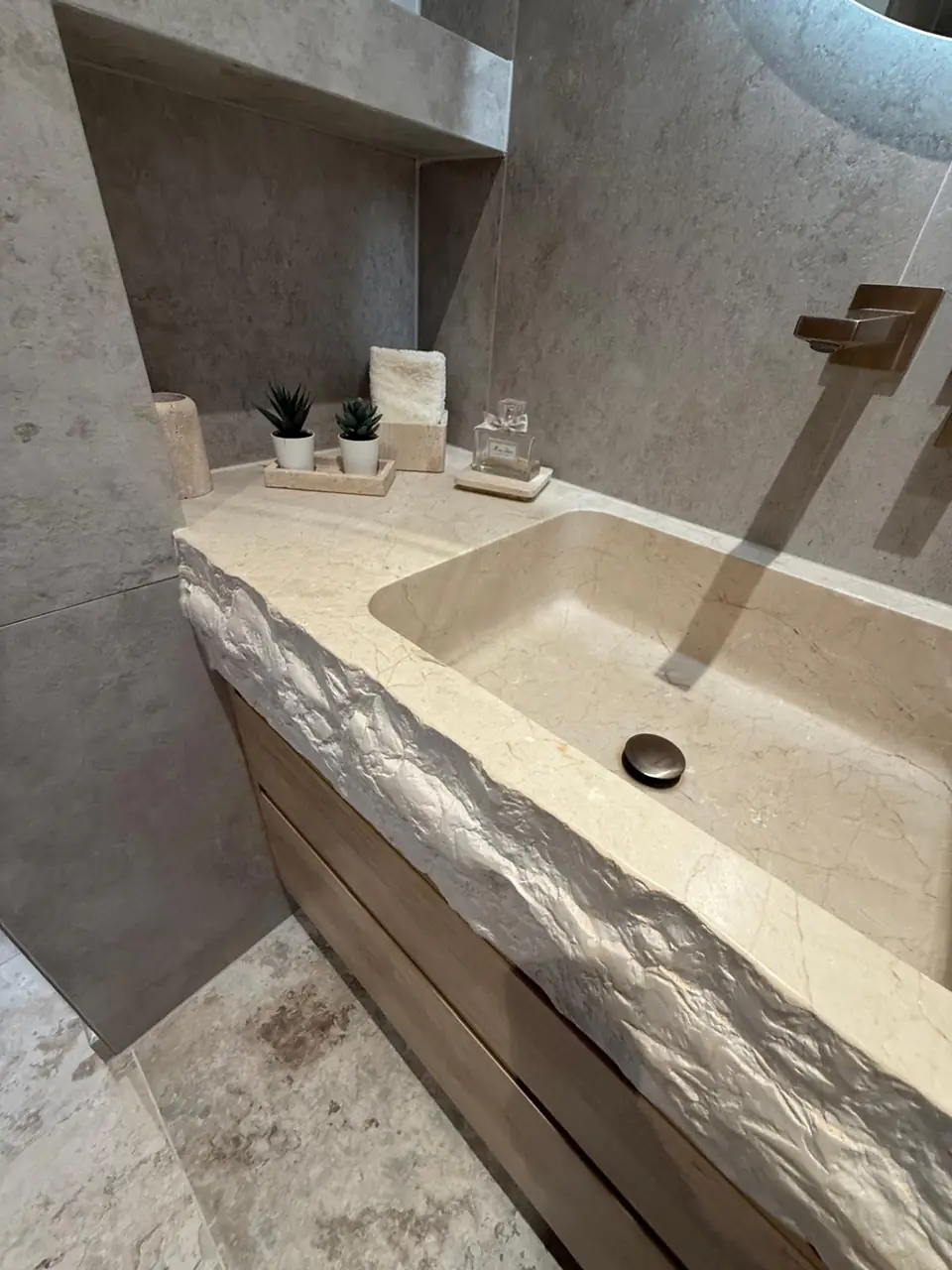 Detalle del baño de la casa de Eliseo y Sophie con piedra, madera y acabados en bronce 1