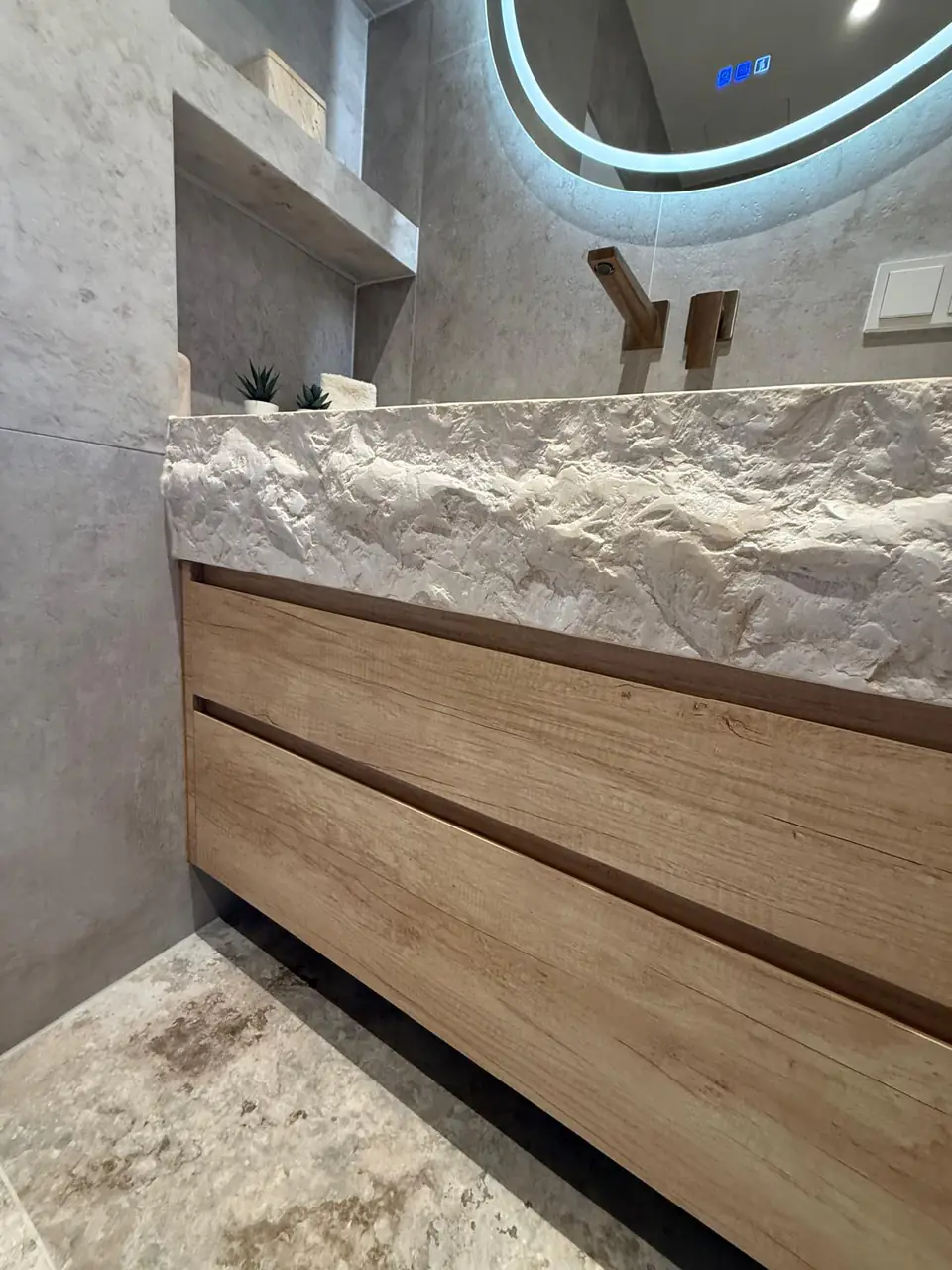 Detalle del baño de la casa de Eliseo y Sophie con piedra, madera y acabados en bronce 3