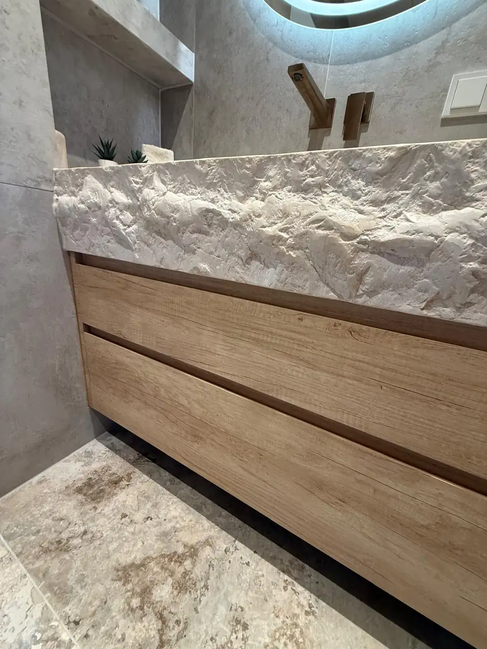 Detalle del baño de la casa de Eliseo y Sophie con piedra, madera y acabados en bronce 4