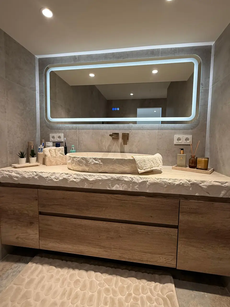 Detalle del baño de la casa de Eliseo y Sophie con piedra, madera y acabados en bronce 18